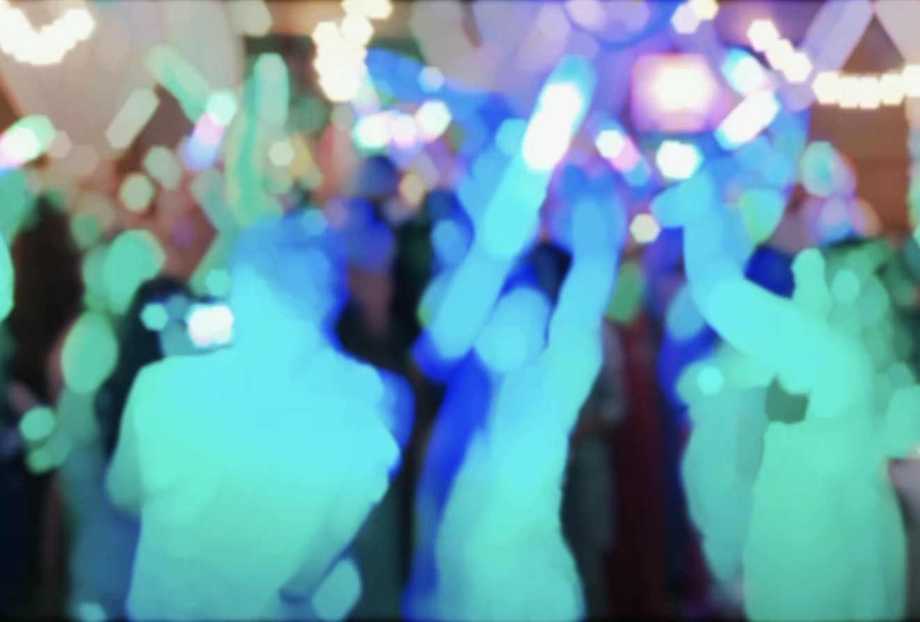 Packed dance floor under colorful lights at the Elton Wedding